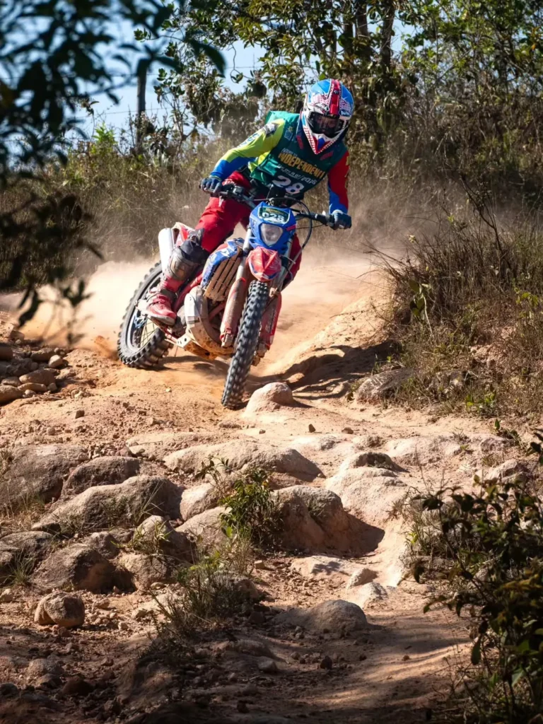 Fotografia de Fabiano Godoy: piloto de enduro em uma curva com pedras e poeira.