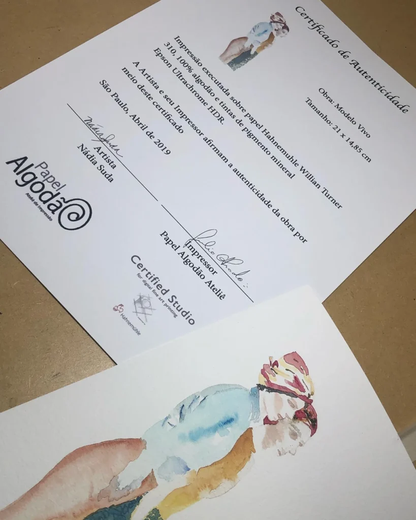 Fotografia publicada por Nádia Suda: reprodução da aquarela Modelo Vivo junto ao certificado de autenticidade assinado pela artista e pelo impressor Júlio.